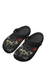 Angled view of black clogs featuring death moth and red flame tattoo-style print