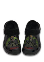 Black fuzzy slippers with zombie skull and "More Brains!" print