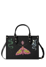 Front view of Mystic Moth and Serpent Handbag with pink moth, emerald snake, and celestial floral serpent on black PU leather background