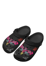 Angled front view of black clogs showing vivid neon wing artwork