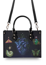 Top handle and adjustable crossbody strap of the cosmic heart print bag