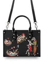 Back of structured black handbag with classic tattoo art of girls and dogs