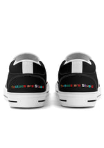 Rear view of slip-on sneakers with white trim and multicolored "Tattoos are Stupid" text on heel
