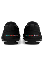 Heel view of black "Tattoos are Stupid" shoes with rainbow embroidered text on both shoes