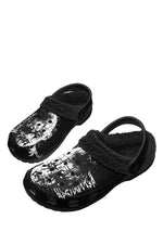 Angled side view of horror-themed black slippers with spiked head design