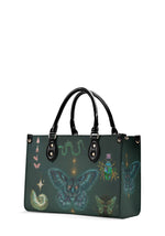 side view of alchemy-themed green tote bag with glowing moth and insect details