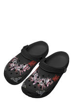 Angled front view of black tattoo slippers showing symmetrical moth art and front holes