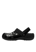 Side profile of black clogs with bold floral and insect illustrations