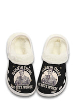 White fuzzy slippers with ironic “Hang In There” vintage design